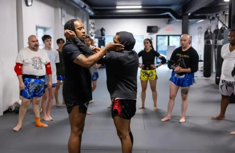 Instructor guiding students during martial arts classes to improve technique and focus