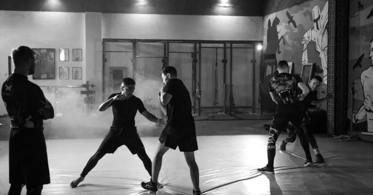 Adults practicing partner drills in class while developing a martial arts training routine for adults