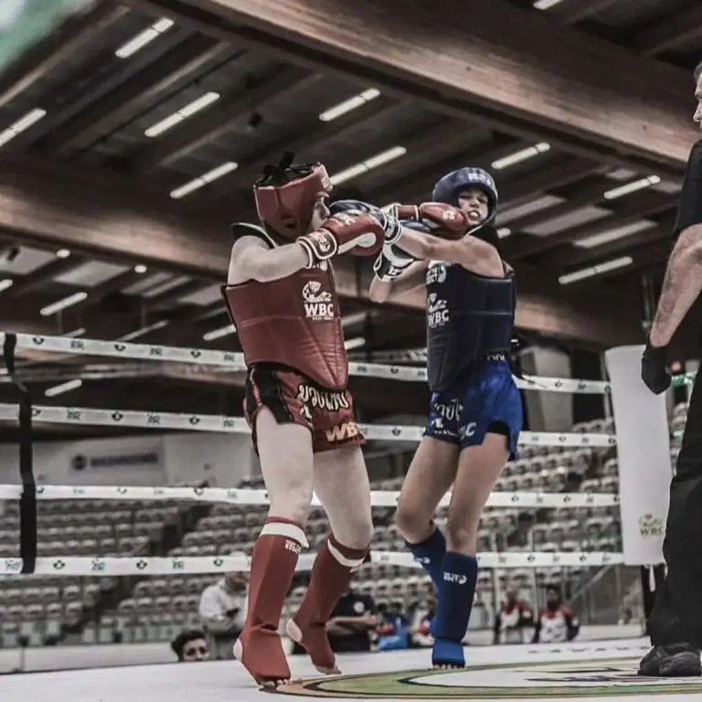 Two martial arts competitors exchanging punches and kicks during a full-contact ring match, showing what makes martial arts different.